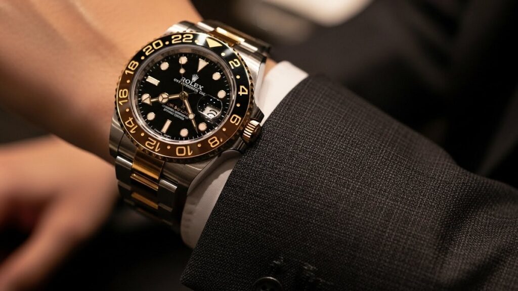 上質なダークスーツの袖口から覗くロレックス カフェオレが象徴するステータス感 